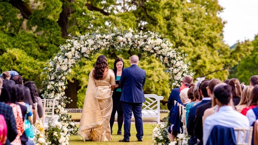 Wedding couple and guests in summer on the Croquet Lawn, Tatton Park, Cheshire